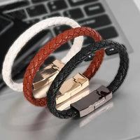 Stylish charging cable bracelets in three colors displayed on a desktop, combining fashion and functionality.